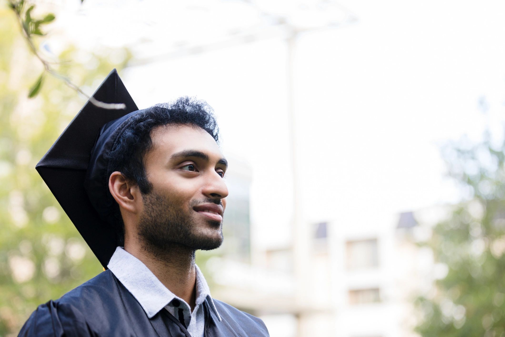 Young adult male graduate looking into the distance