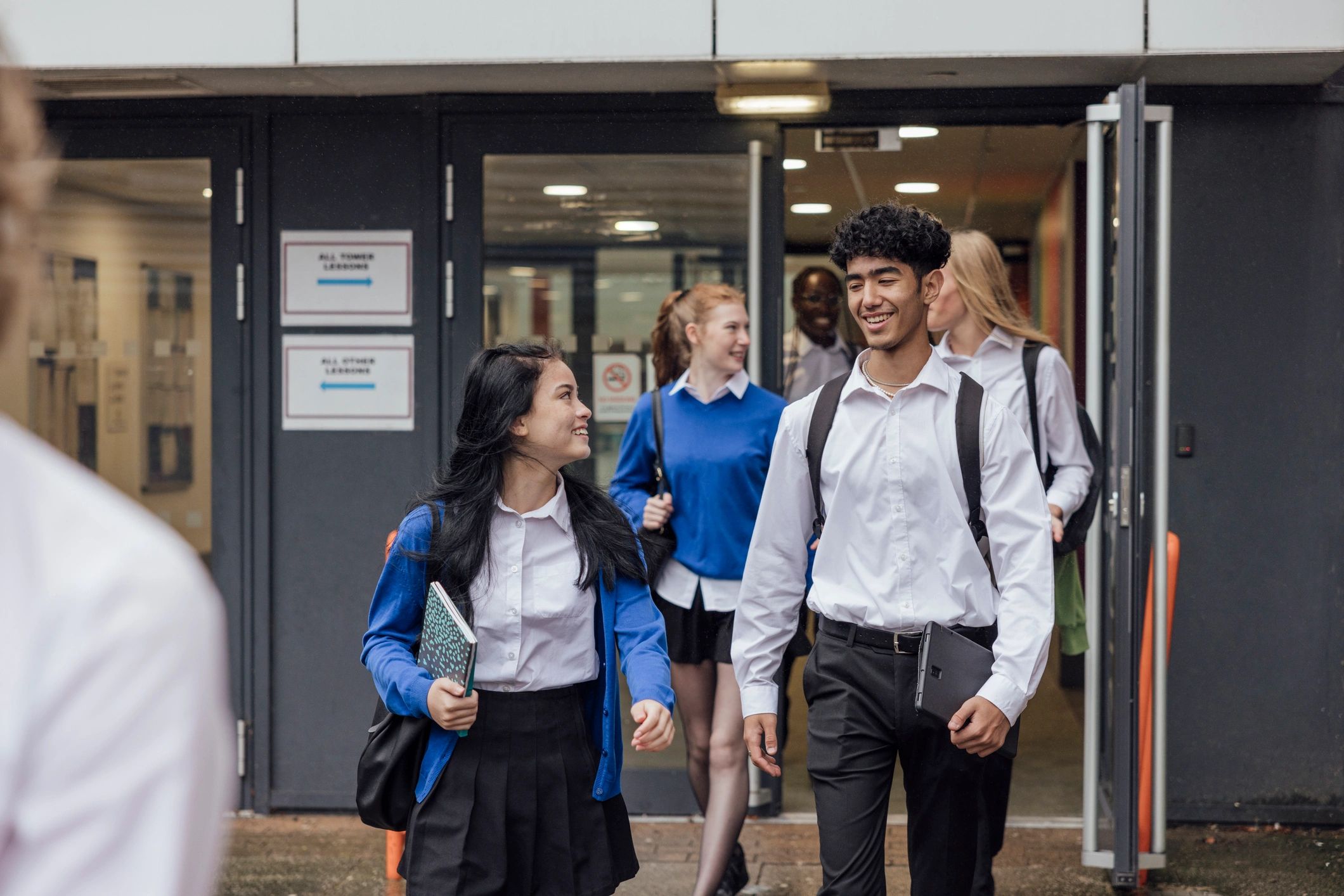 Students in school uniforms walking outside a school building