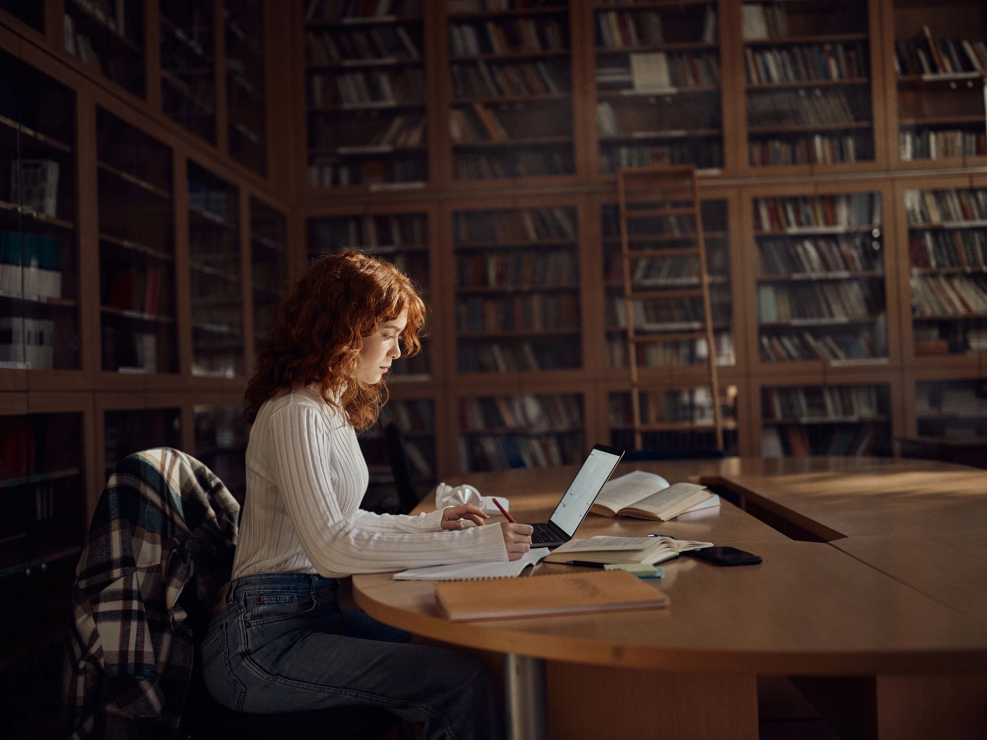 Student studying on a laptop in a library