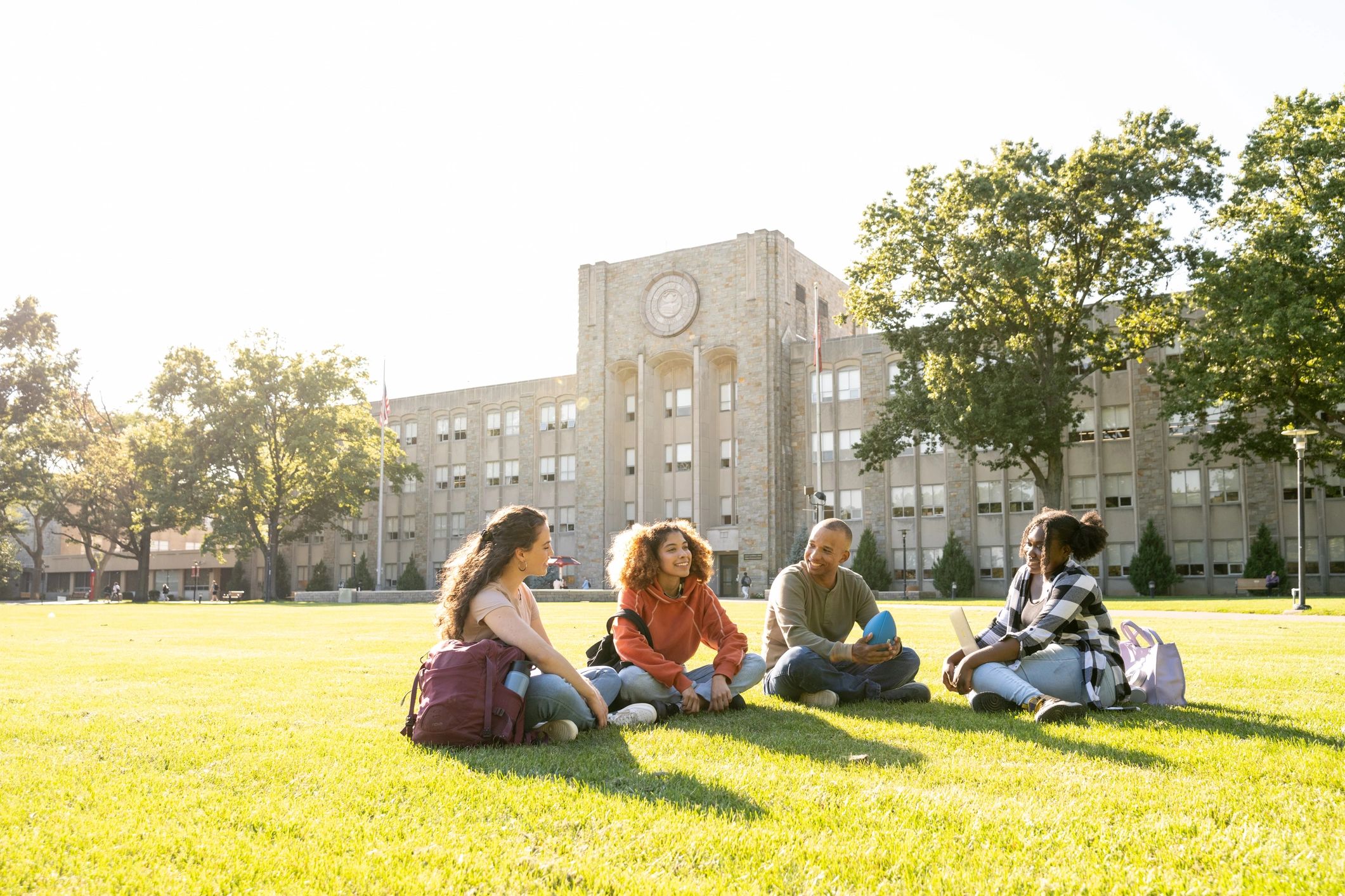 University students hanging out on a campus lawn