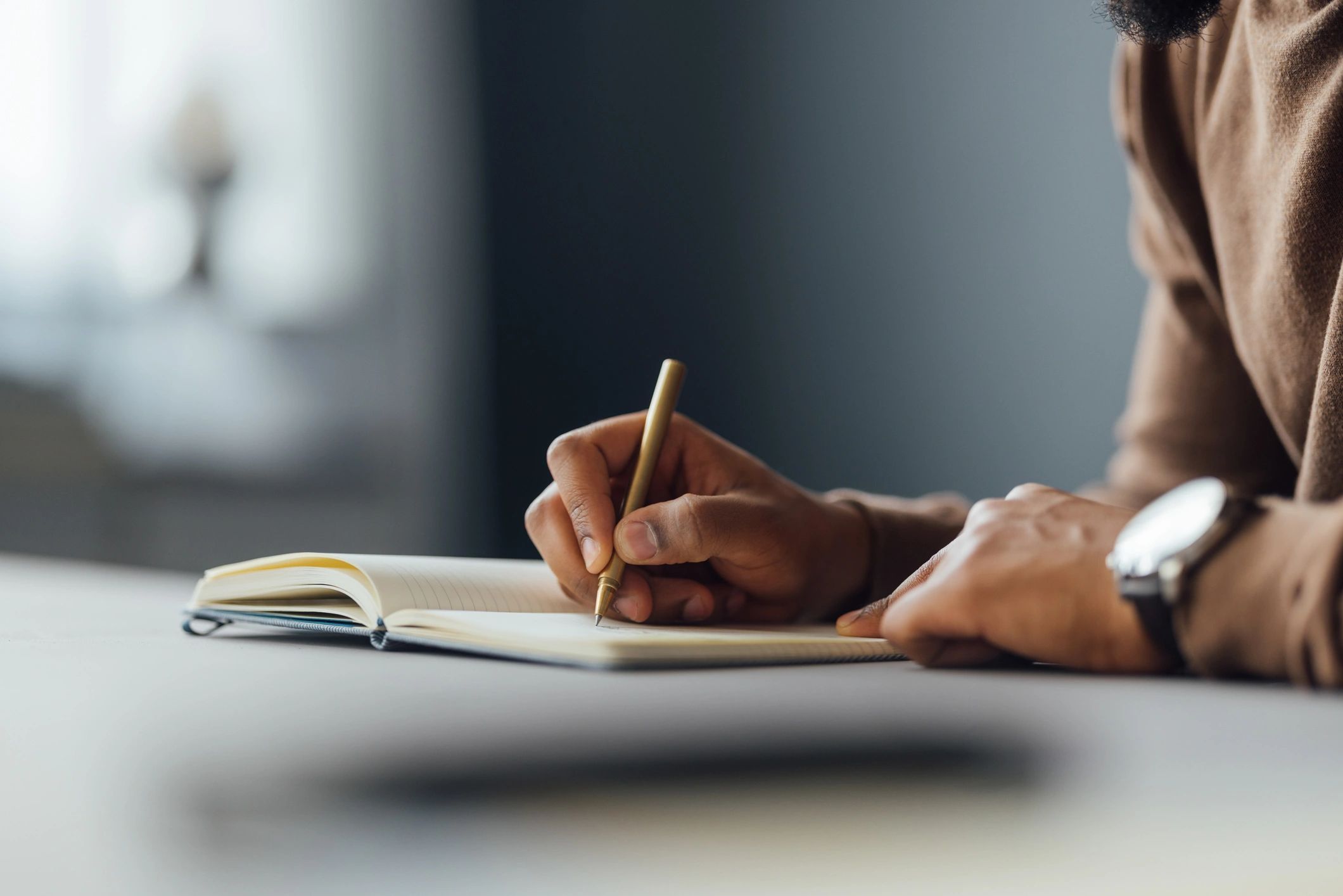Student writing notes at a desk