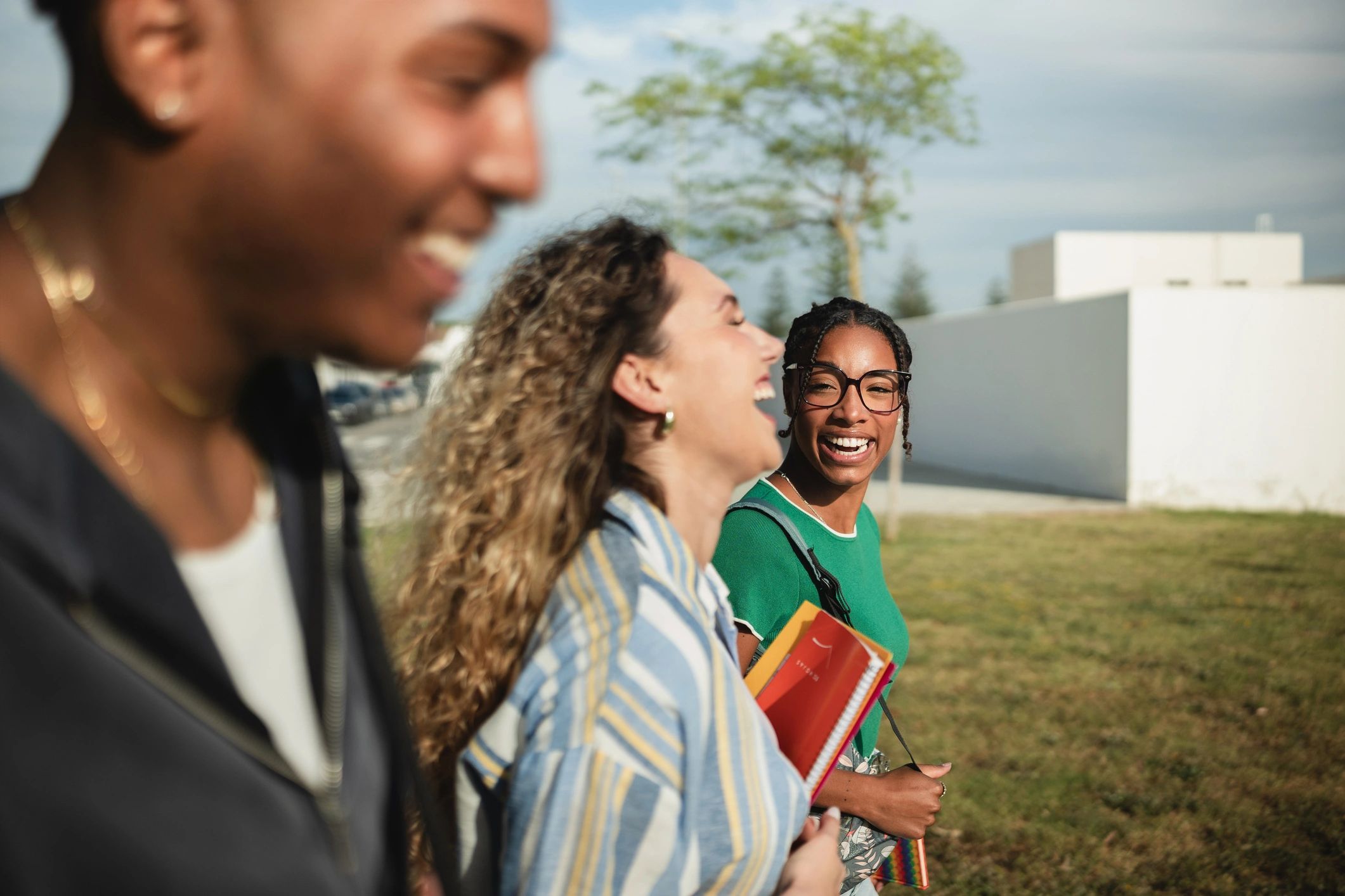 Happy multi-ethnic students walking and laughing together on campus