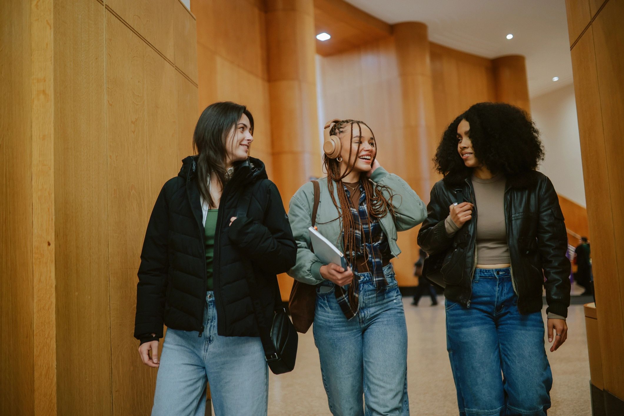 Students walking with laptops and study materials
